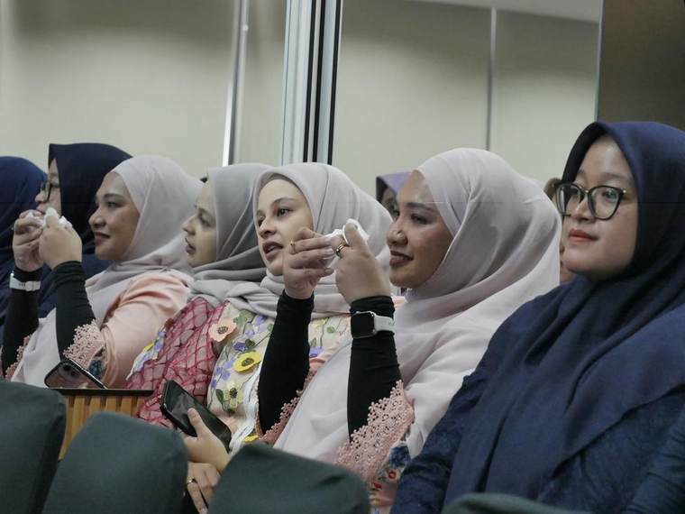 Sederet peserta perempuan berkebaya menyimak sesi dari kursi depan, beberapa memegang tisu.